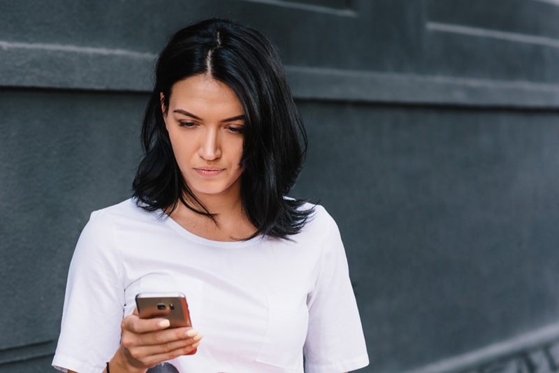 woman looking at her mobile phone with a serious look